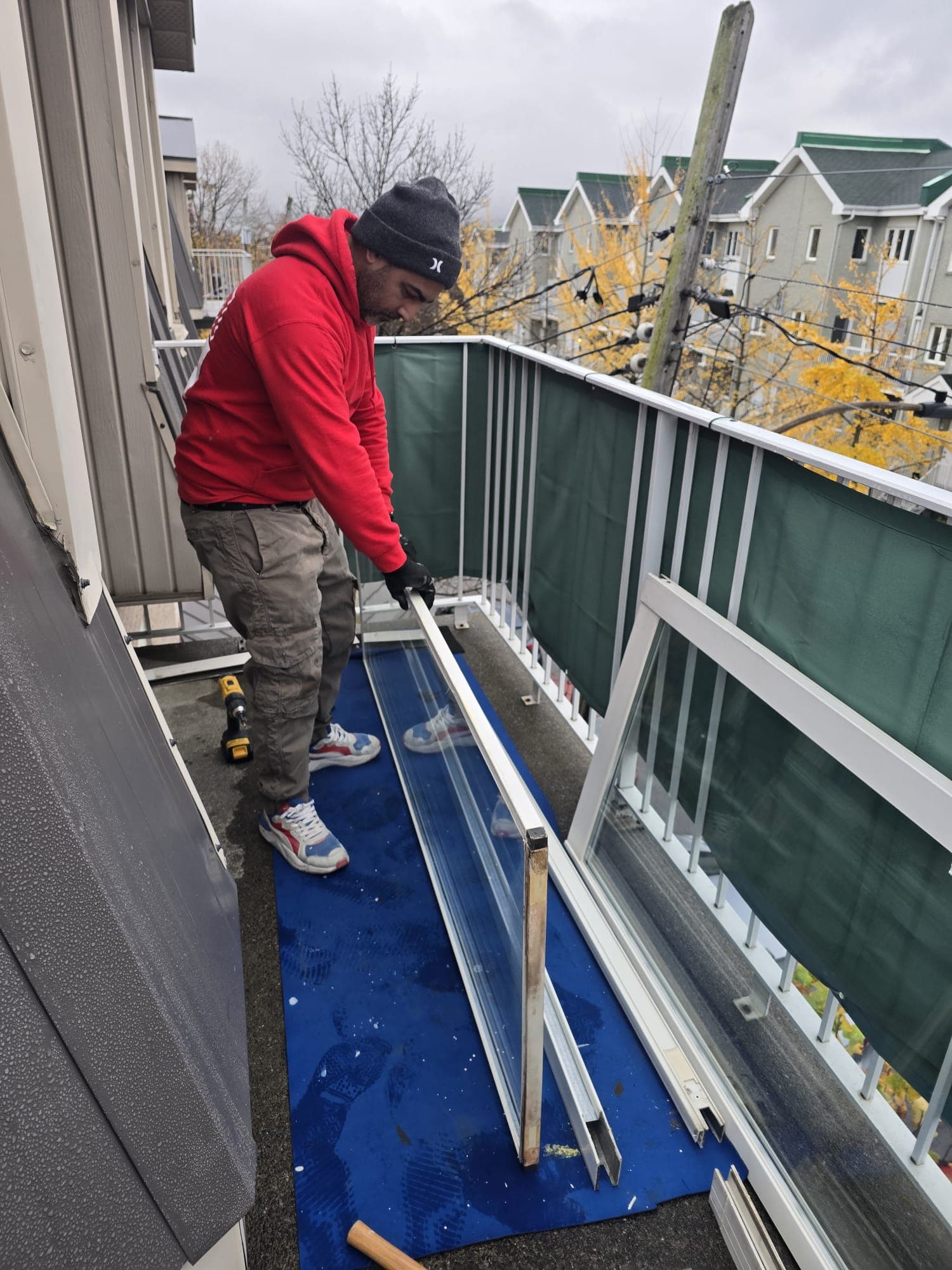 Technicien démontant une porte-patio sur un balcon